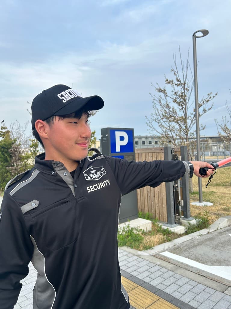 イベント会場で誘導棒を持ち案内にあたる警備スタッフ